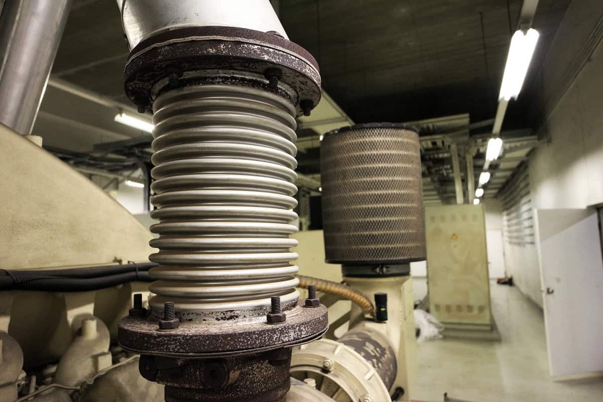 An up-close image of a stainless-steel externally pressurizes expansion joint that is connecting a piping system.